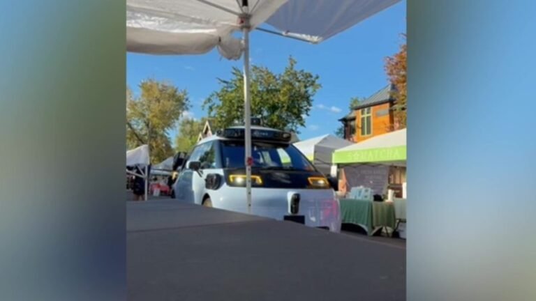 Waymo drives through Denver farmers market during setup